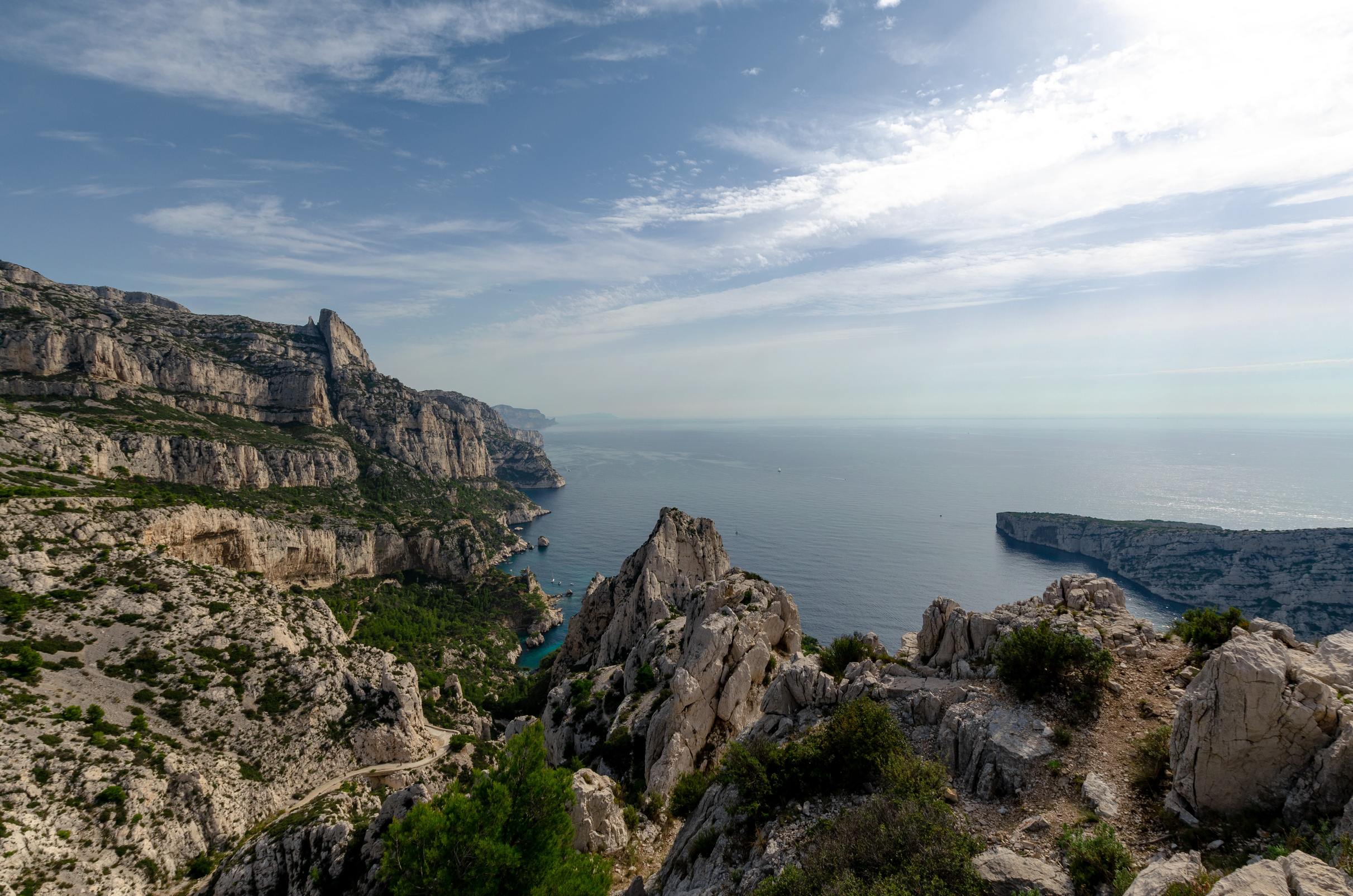 paysage du parc national des Calanques avec vue sur les falaises et la mer et un ciel bleu légèrement nuageux