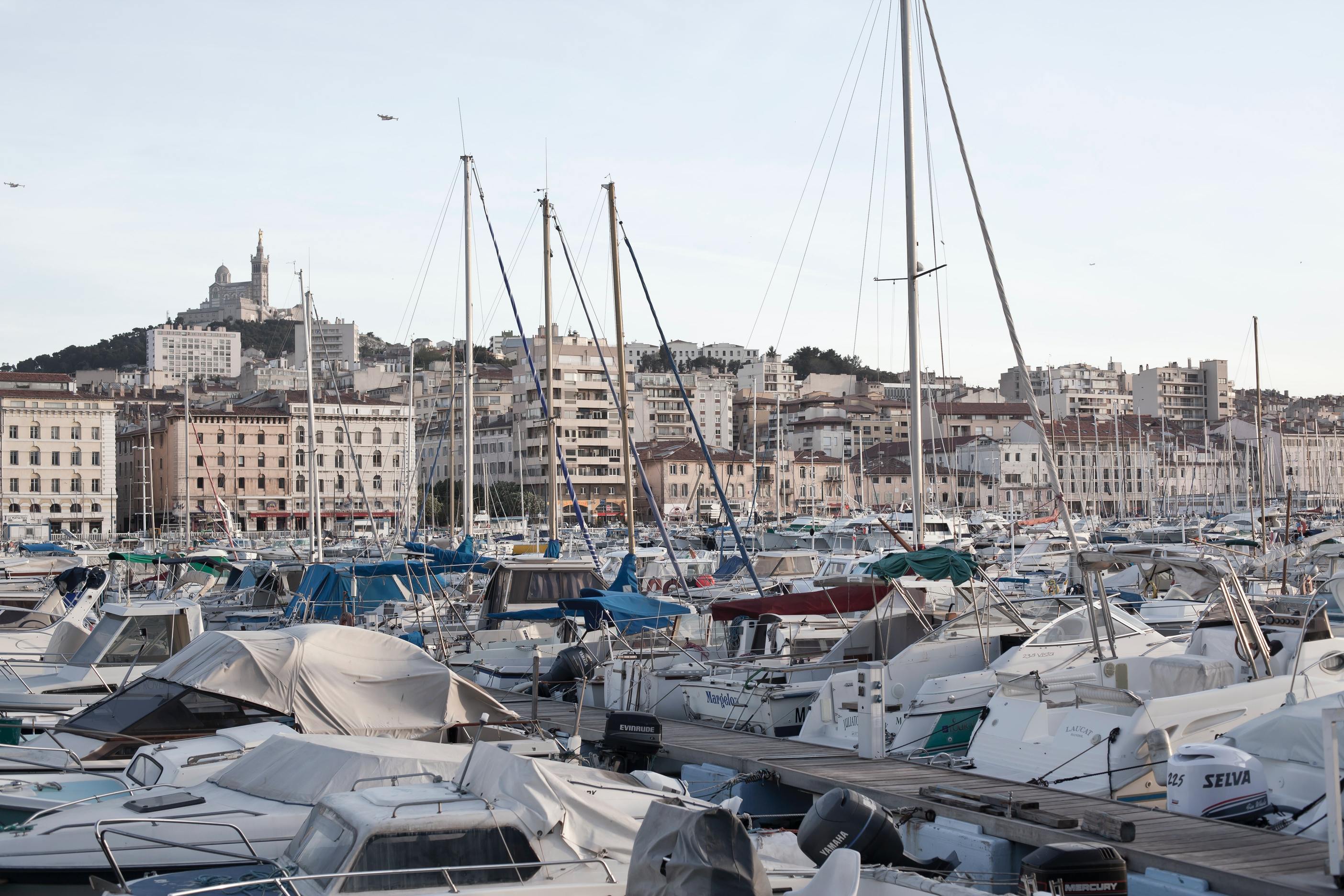 paysage avec vue sur les bateaux à voiles et à moteurs du vieux port de Marseille avec la ville en arrière plan